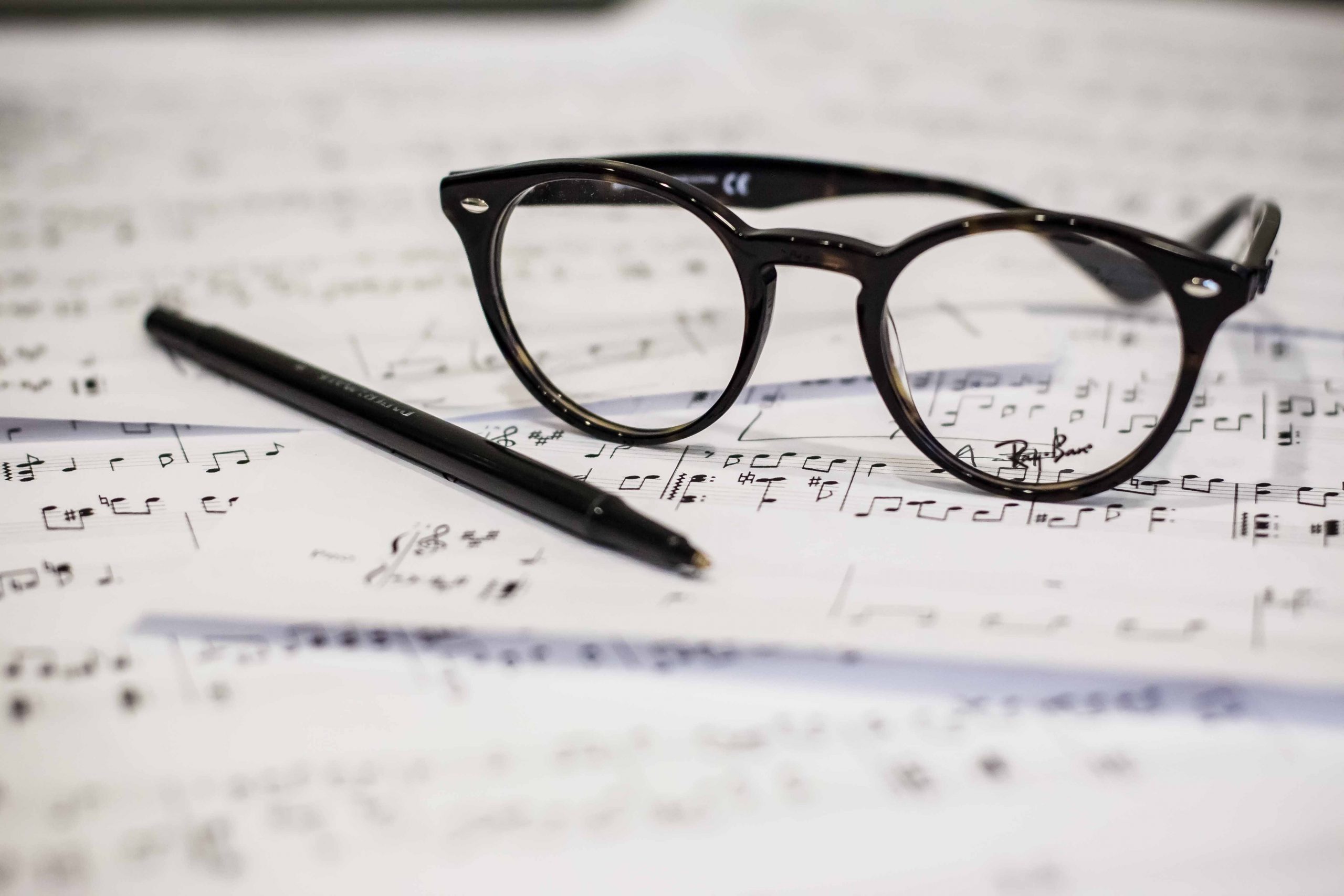 Pen and glasses on music notation pages